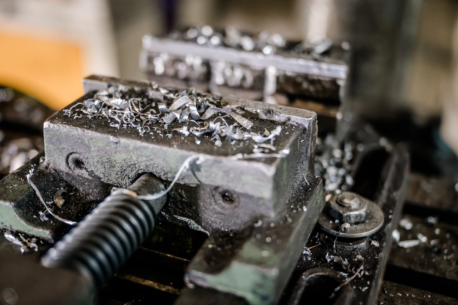 Körfgen - Schlosserei - Dieses Bild zeigt ein Werkstück, das während eines Metallbearbeitungsprozesses in einen Fräsmaschinenschraubstock eingespannt ist.